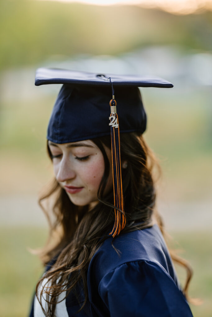 Senior photo headshot with cap and gown in the green grass and trees at Butcher Jones Recreation Site, Salt River, Mesa, Arizona.