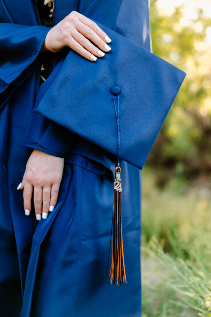 Senior photo session with cap and gown in the beautiful green grass at Water Users Recreation Site, Salt River, Mesa, Arizona.