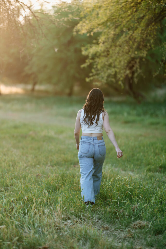 Senior photos in the green grass and trees at Butcher Jones Recreation Site, Salt River, Mesa, Arizona.