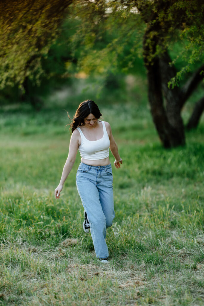 Senior photos in the green grass and trees at Butcher Jones Recreation Site, Salt River, Mesa, Arizona.